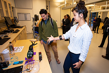 Kinesiology major Danica Cooley demonstrates a robotic arm.