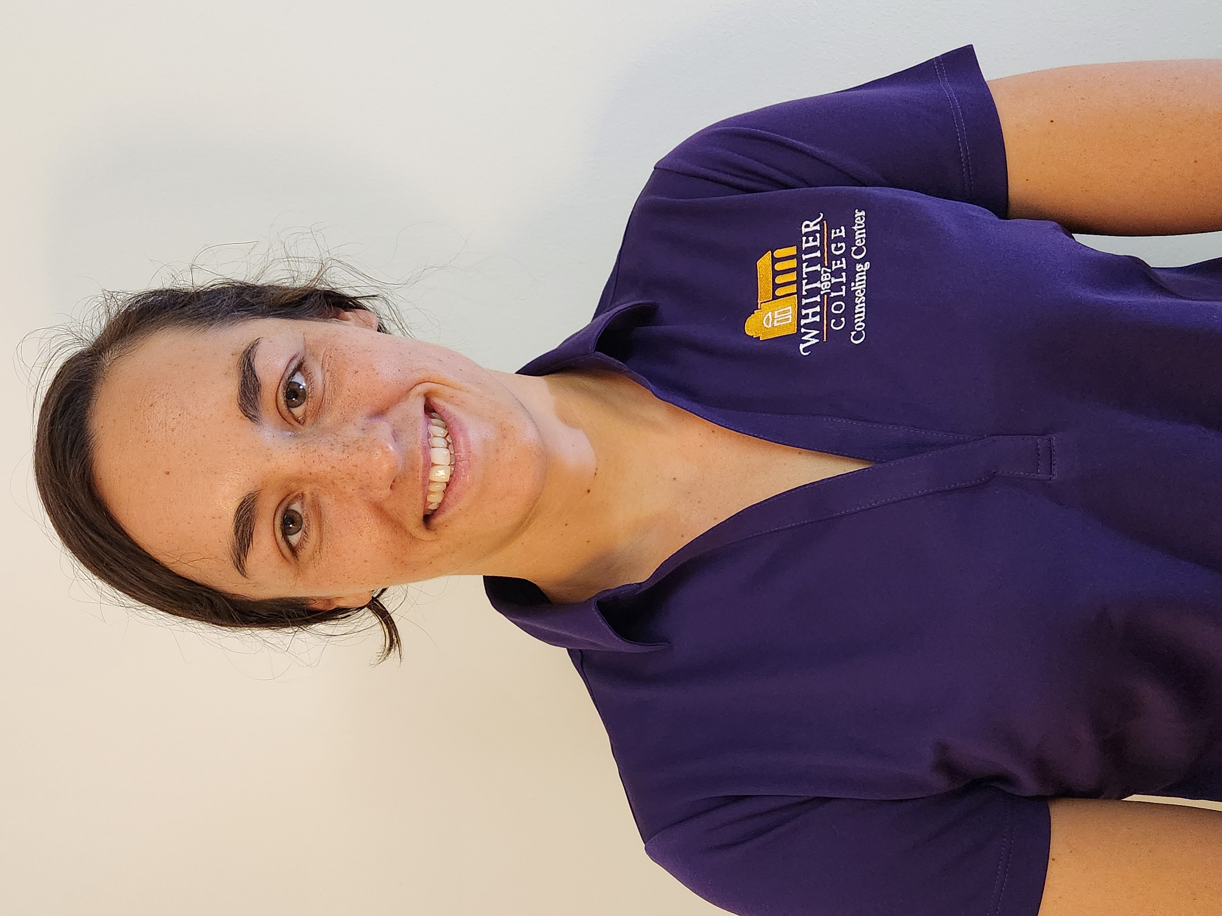 Anika Apostalon in Whittier College purple polo shirt in front of white wall