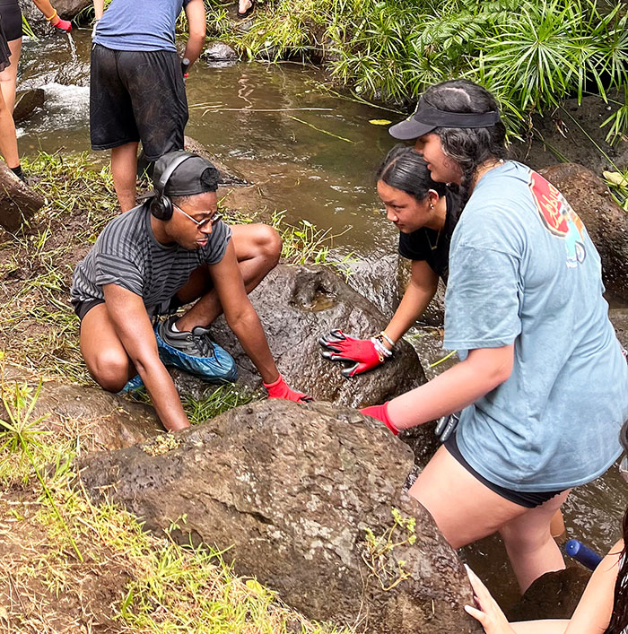 Students working with a boulder