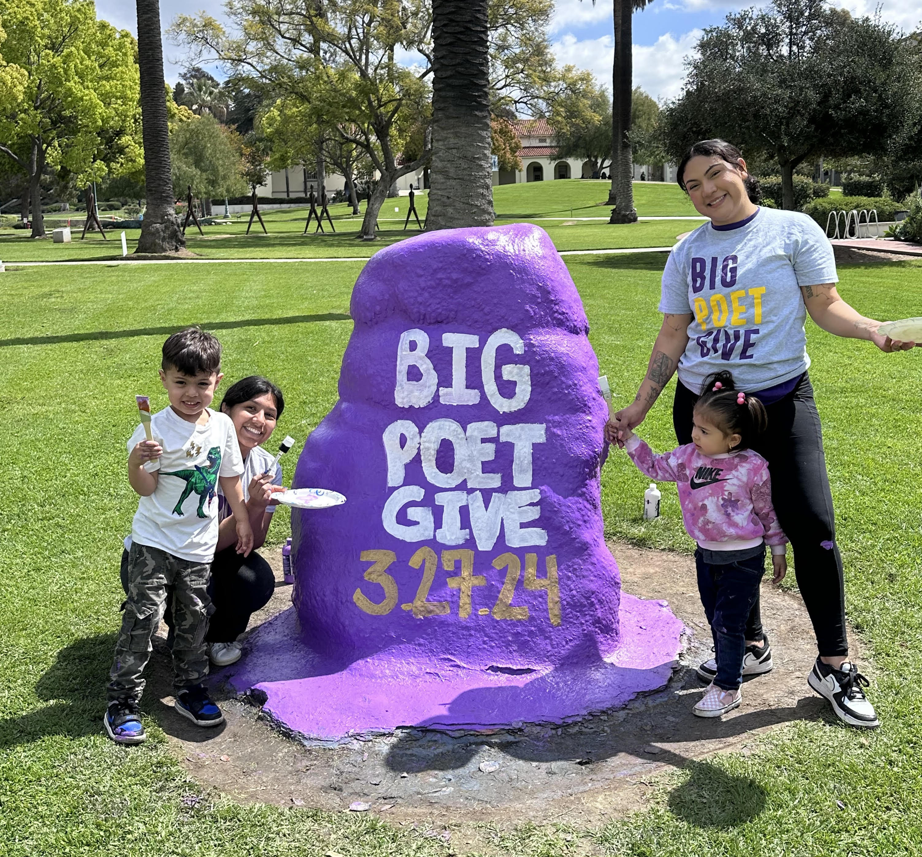 Brenda Garcia, right, paints the rock for Big Poet Give with her two children and Jaime Luna. | Courtesy Brenda Garcia