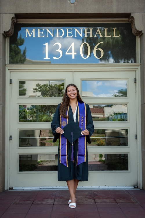 Marin in front of Mendenhall in grad regalia