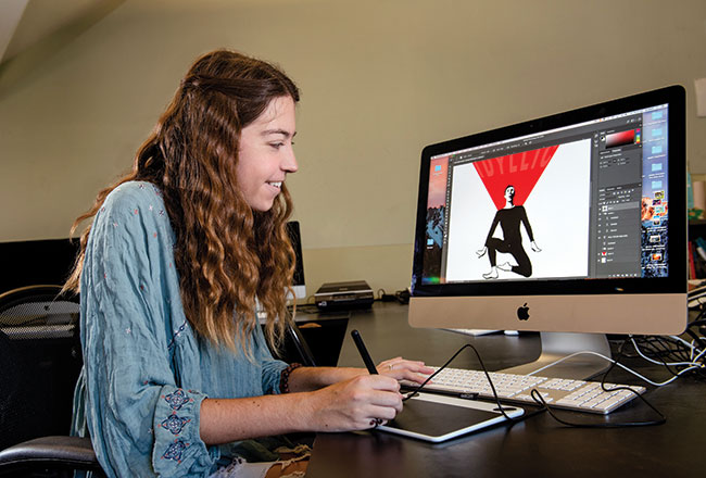 Lauren Swintek working on digital art at a computer.