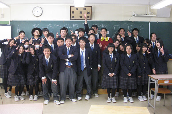 Robert Kondo poses for a photograph with a classroom of Japanese students.