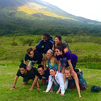 Students pose for a photograph in a pyramid formation in Costa Rica during an environmental trip.