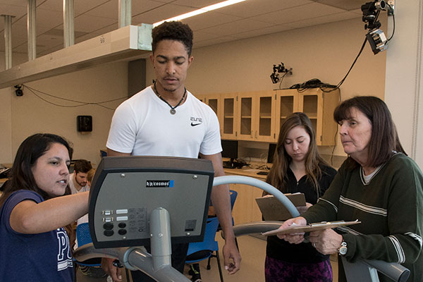 Students operating treadmill in movement lab