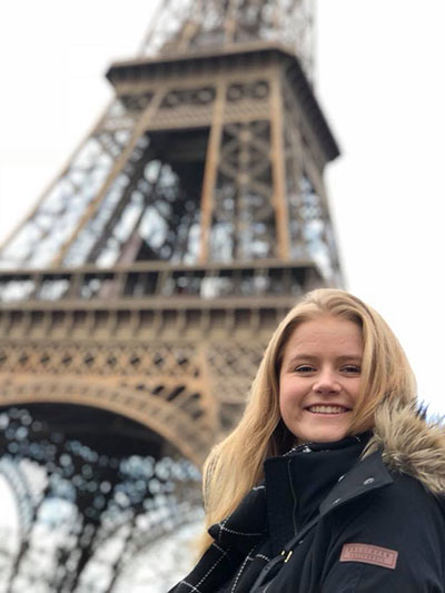 Alyssa Hayne poses for a photograph in front of the Eiffel Tower.