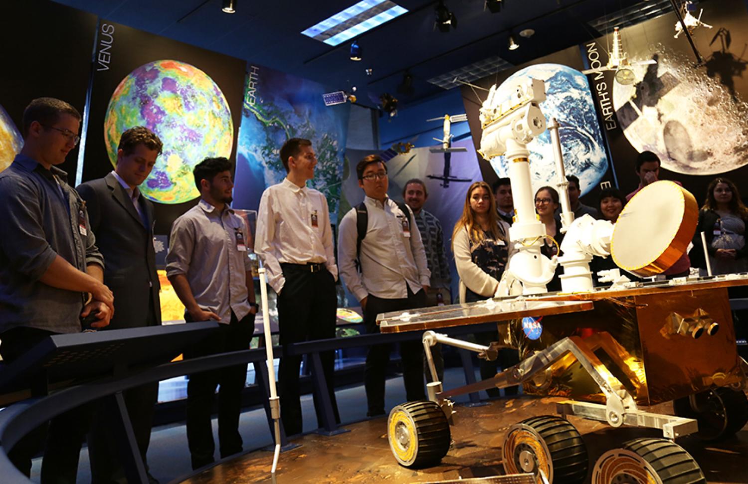 Students look at a rover model