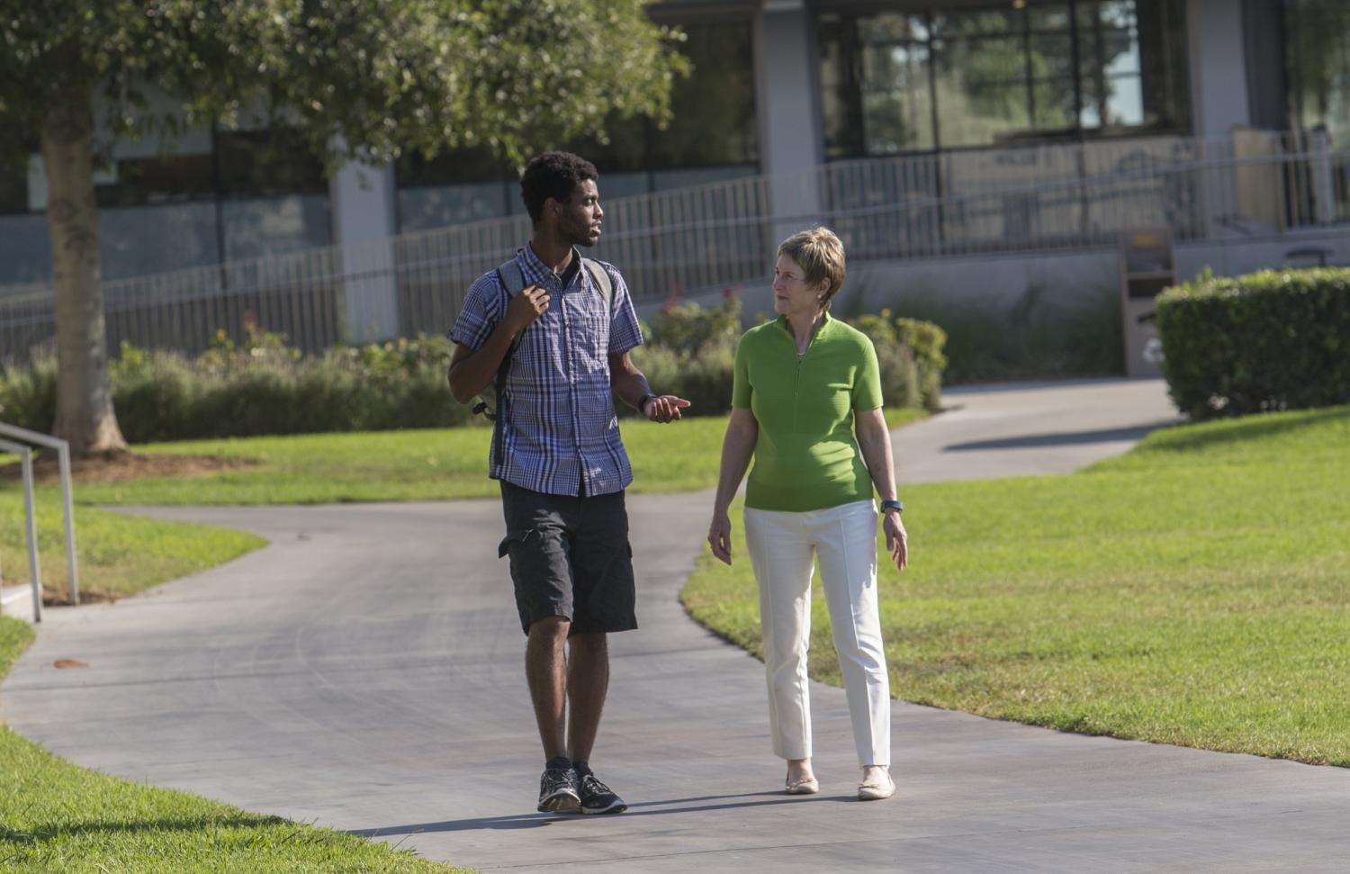 Student and professor walking on campus