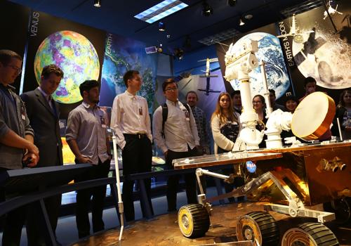 Students look at a rover model