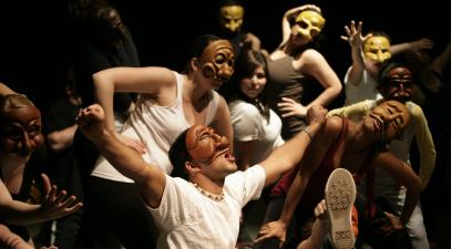 Students perform on stage with masks