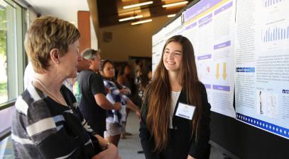 A student presents her research to President Herzberger