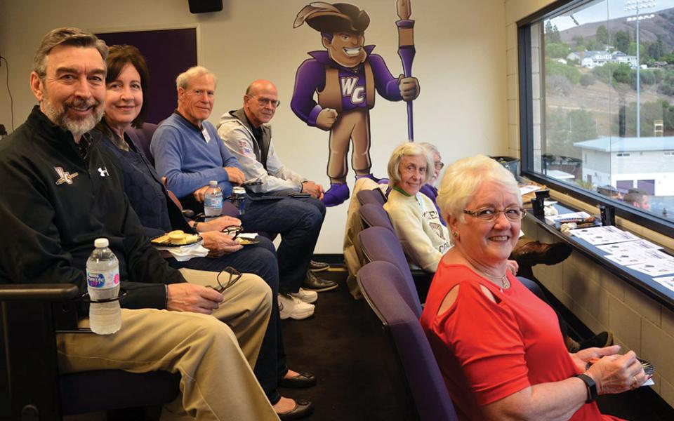 A group of alumni in box seats.