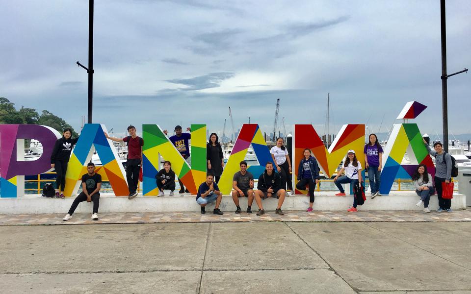 Students and professor Sylvia Vetrone pose for a photo among giant letters spelling Panama.